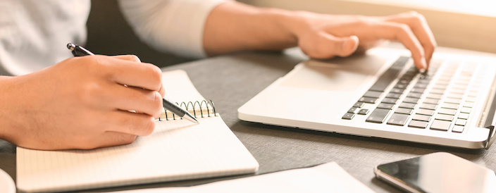 man sat with notebook and laptop